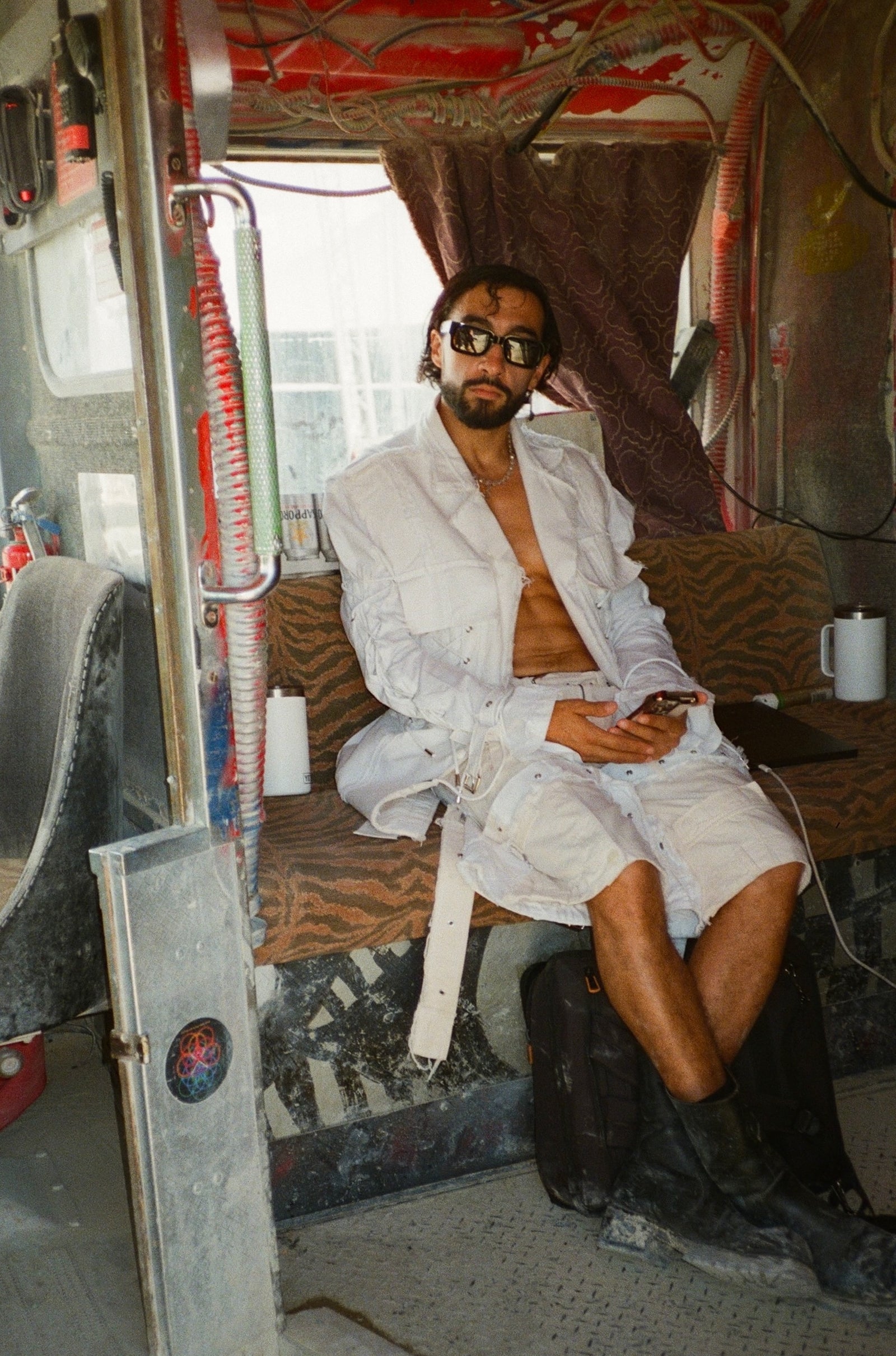 Sofiane Pamart au Burning Man, assis dans un véhicule décoré en plein désert