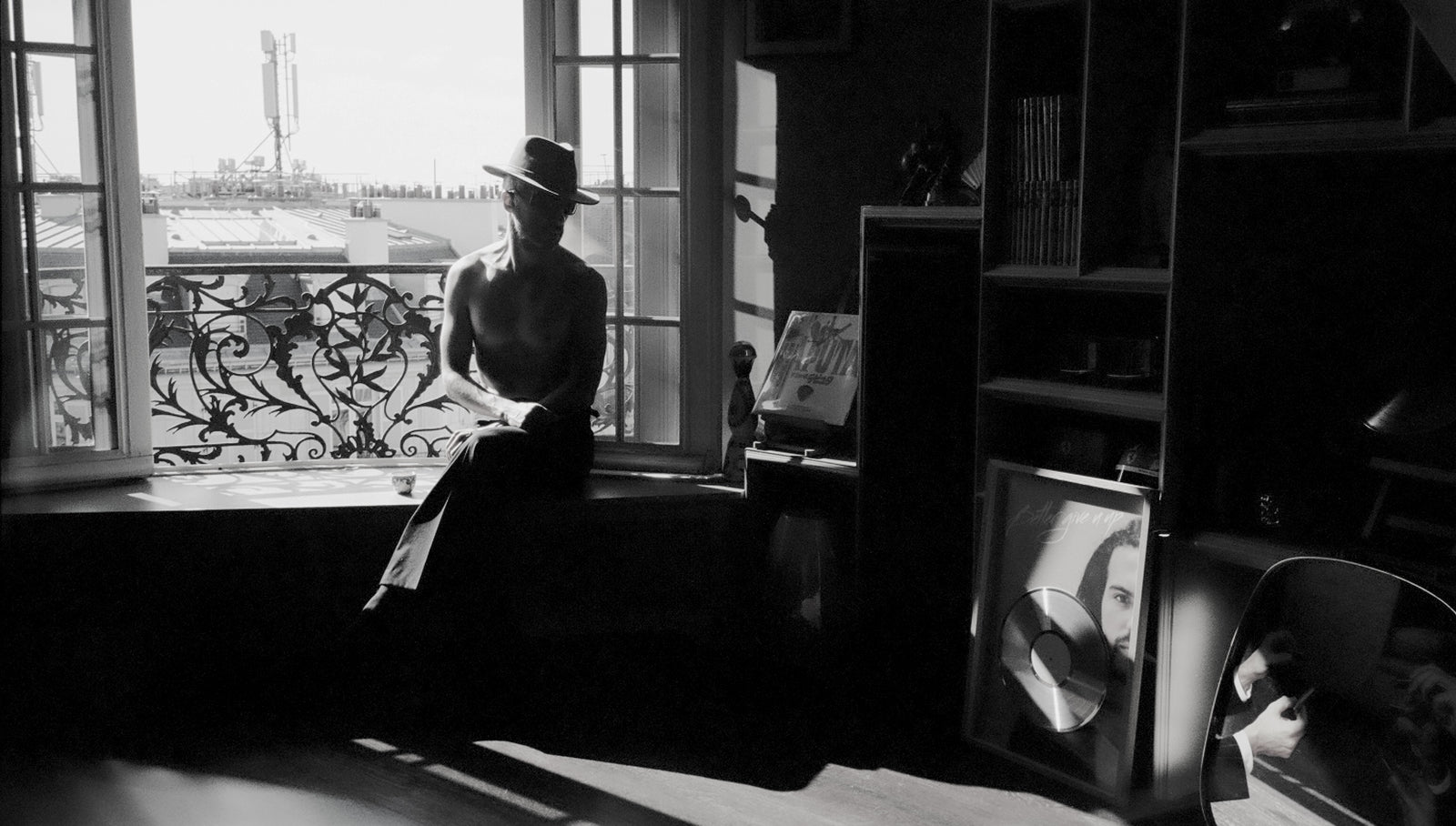 Sofiane Pamart à une fenêtre à balcon parisienne, en noir et blanc