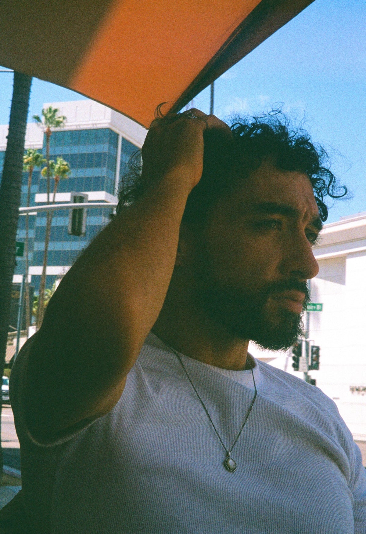 Sofiane Pamart sous un auvent dans une rue de Los Angeles, palmiers en arrière-plan